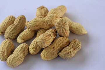 Whole unshelled peanuts on white background, perfect for food, nutrition, and healthy snack concepts in natural composition