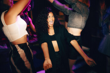 Vibrant group of friends celebrating and dancing in an energetic nightclub setting
