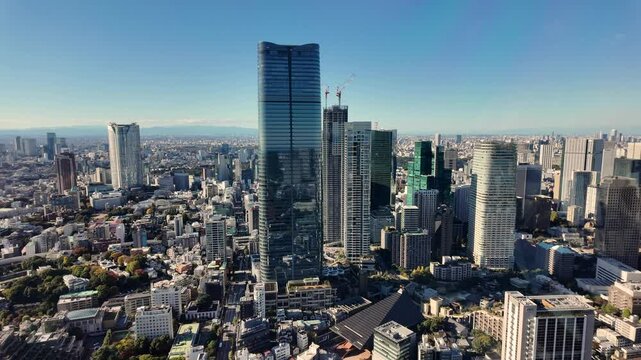 Modern skyscrapers rising above Tokyo cityscape in Minato ward with Azabudai Hills, featuring Mori JP Tower, under a clear blue sky
