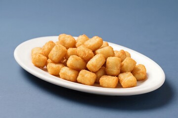 Fototapeta premium Plate of fried potato bites with tomato sauce, perfect for food blogs, restaurant menus, or social media posts showcasing delicious appetizers. AI Generate
