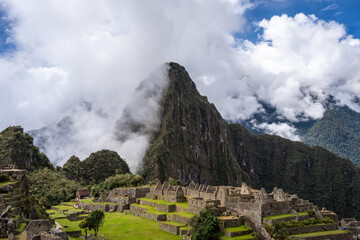 Panoramic view of Machu Picchu ruins surrounded by misty mountains, Peru