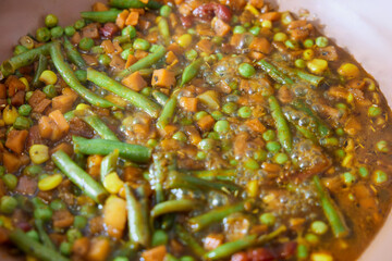 vegetables are cooked in a frying pan in a home kitchen
