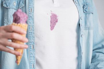 Close up melting purple ice cream in waffle cone in the background dirty stain on white clothes....