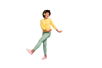 Full length body size photo of wavy curly haired sweet pretty girl of freedom wearing green pants trousers dancing listening to her music out of headphones isolated over violet color pastel background