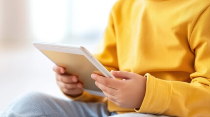 Child in Yellow Sweater Engaged with Tablet Technology indoors