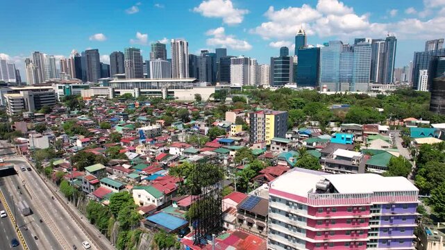 Makati, Metro Manila: Apr 17, 2025 - Aerial of East Rembo homes in Makati with Bonifacio Global City skyscrapers in the background. Example of social divide.
