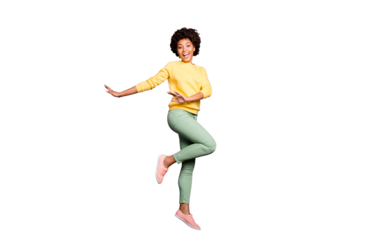 Full length photo of funky funny brunette curly hair afro american girl dance fun on fall spring vacation free time feel candid jump wear casaul style outfit isolated violet purple color background