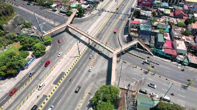 Makati, Metro Manila: Apr 17, 2025 &mdash; Top view of pedestrian overpass crossing the busy C5 and Kalayaan Avenue junction, with visible traffic flow and urban layout.