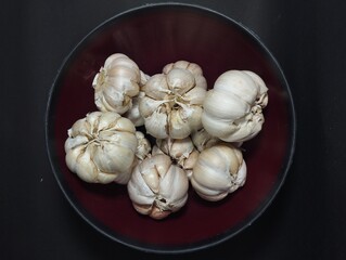 Garlic in a bowl isolated on black background
