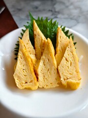 Sweet egg ,Tamago, sashimi on white plate.