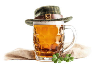 Glass mug of beer with green leprechaun hat and shamrock isolated on a clean white background