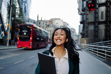 Happy businesswoman walking in the city
