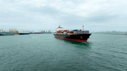 Obraz premium container ship carrying goods for international import export, business and industry regarding cargo transportation services to consumers and dealers by container ship around the world,