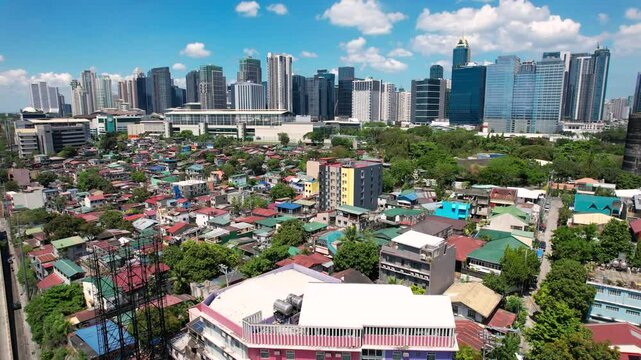 Makati, Metro Manila: Apr 17, 2025 &mdash; Panning aerial of East Rembo homes in Makati with Bonifacio Global City skyscrapers in the background. Example of social divide.