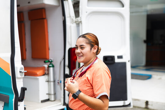 Nurse standing outside an ambulance smiling during the day