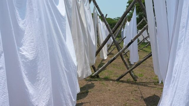 Dhobi Ghat, open air laundry in Kochi, India, cleaned clothes hanging on clothes line to dry, washing bed sheets and linen