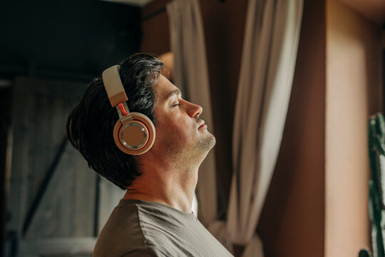 Man relaxing indoors with headphones, enjoying music and tranquility