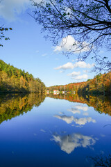 Landscape at the Seehofweiher pond in the Porzbach Valley. Waters along the Porzbach stream in the forest. Autumnal nature at the bathing lake.
