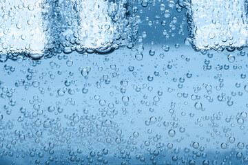 Soda water with ice cubes as background, closeup