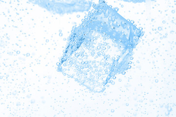 Soda water with ice cubes as background, closeup