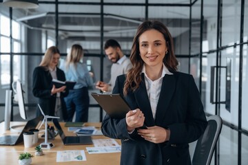 Woman is in front of her colleagues. Business people are working in the office