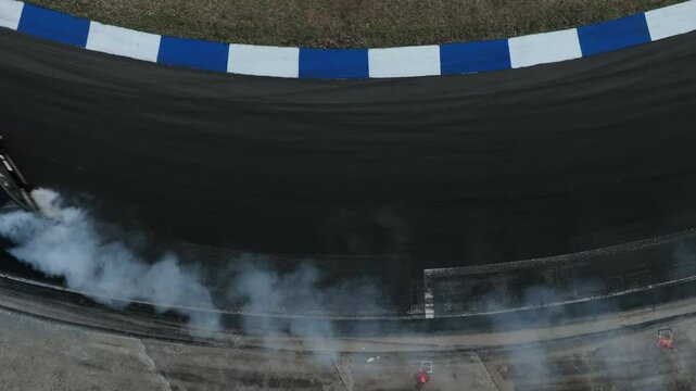 Aerial view car drift on asphalt race track with lot of smoke from burning wheel tires rubber, Drift motorsport car drift race, Professional driver drift car on asphalt race track, Car motion blurred 