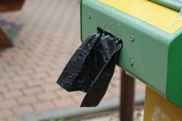 dispenser of black waste bags for pet owners to access and dispose of dog waste responsibly.