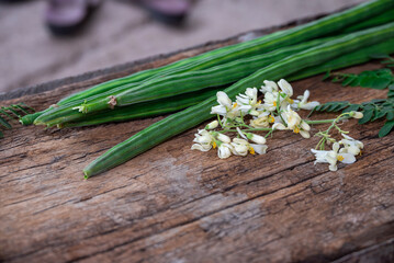 Healthy drumstick pods vegetable and leaves. Moringa Oleifera with leaves on wooden background