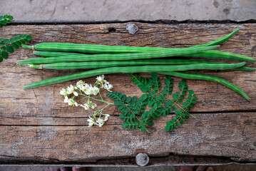 Healthy drumstick pods vegetable and leaves. Moringa Oleifera with leaves on wooden background