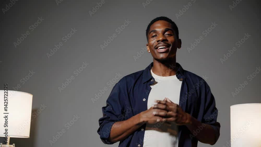 Poster a mid-shot video captures a person gesturing expressively in a minimalist setting with soft lighting
