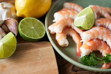 Fresh shrimps with lime and parsley on plate, closeup