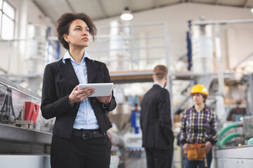 Female quality inspector using tablet pc at factory