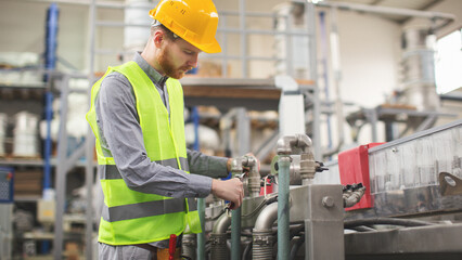 Young man repairing a machine in factory