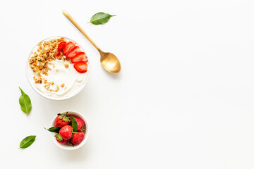 Healthy breakfast flat lay. Yogurt with muesli and strawberry in bowl. Top view