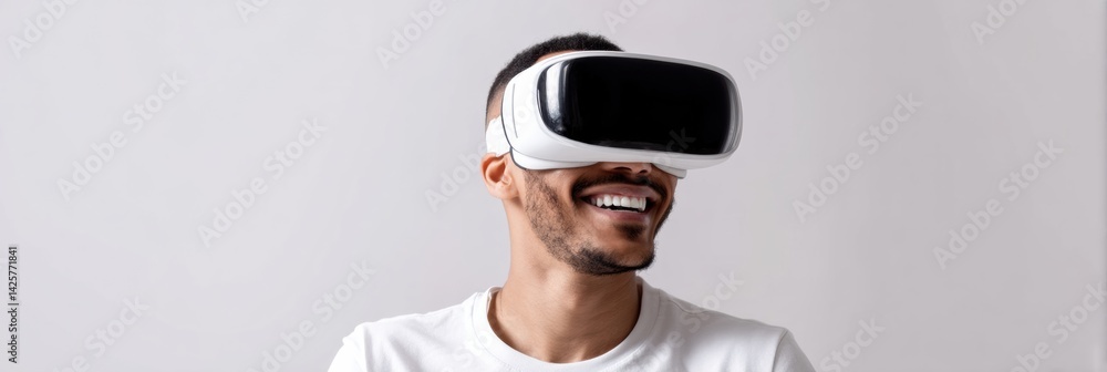Fototapete happy man enjoys virtual reality experience while wearing white vr goggles against a flat white back