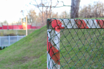 Chain-Link Fence on Hill Slope with Red and White Warning Stripe Creating Clear Safety Boundary in...