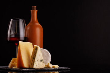 A refined selection of aged cheeses presented on a board, accompanied by a glasses of wine