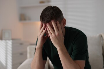 Depressed man on sofa at home. Mental health problem