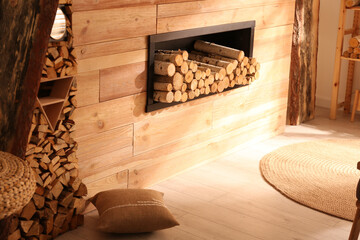 Decorative fireplace with stacked wood in cozy living room interior