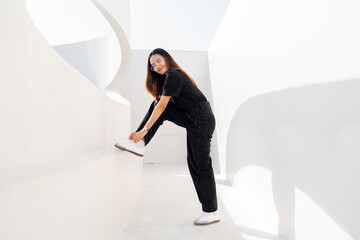 Woman tying shoelaces in casual outfit outdoors