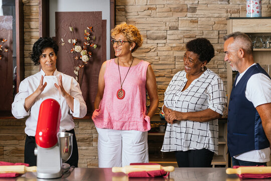 Chef teaching cooking class to diverse group of seniors