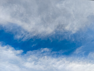 Blue sky with dramatic white and gray cloud formations, creating a textured and atmospheric natural scene