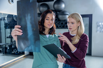 Doctor in lab coat explaining xray results to a female patient