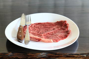 a piece of raw meat, steak on a plate, beef