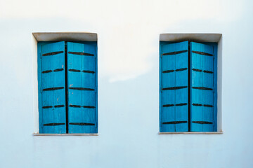 Traditional Greek architecture with blue wooden shutters in Plaka village, Milos Island