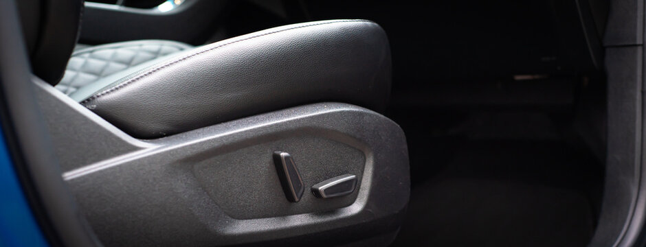 Panorama view power seat adjustment switches to raise height or press down to lower front part of seat cushion on modern SUV car, leather passenger seat memory position adjusting buttons controls