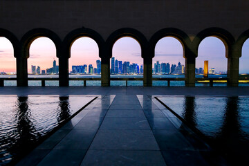 Arches and city of Doha at sunset, Qatar