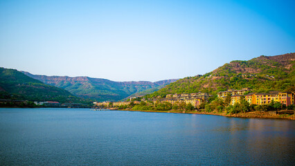 Beautiful view of the Lavasa city, Pune on the shore of the lake in India with hills in the background. 16:9 ratio landscape, blue view, sunset, Nature Wallpaper