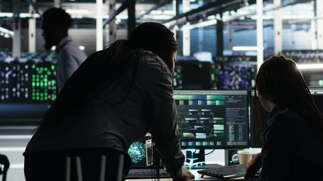 Data center teamworking colleagues use node tree program to identify equipment performance issues. Server hub engineering team coworkers review data analysis graph to minimize failures, camera B