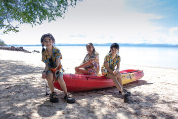 Obraz premium Children and family having fun on the beach with water activities like kayaking and canoeing under a bright summer sky